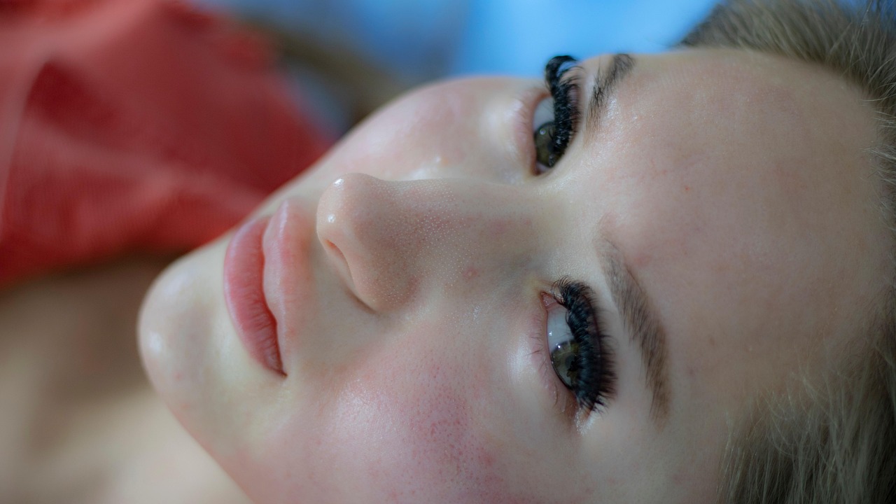 Close-up of a woman's face and smooth skin as she lies back
